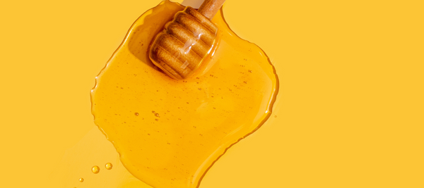 Stock image of honey on a yellow background