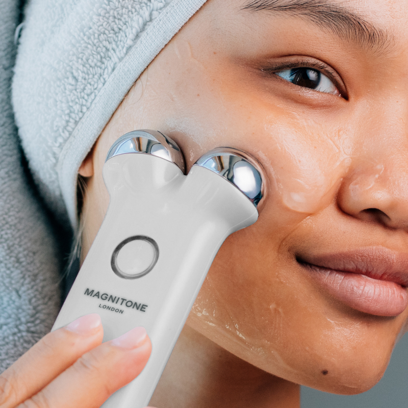 MAGNITONE Take Me Hya Hydrating Superconductive Gel with Aloe Vera + Hyaluronic Acid on model's cheek being used with LiftOff Microcurrent Facial Toning Device